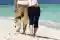 Imagen de una pareja de espaldas andando por una playa